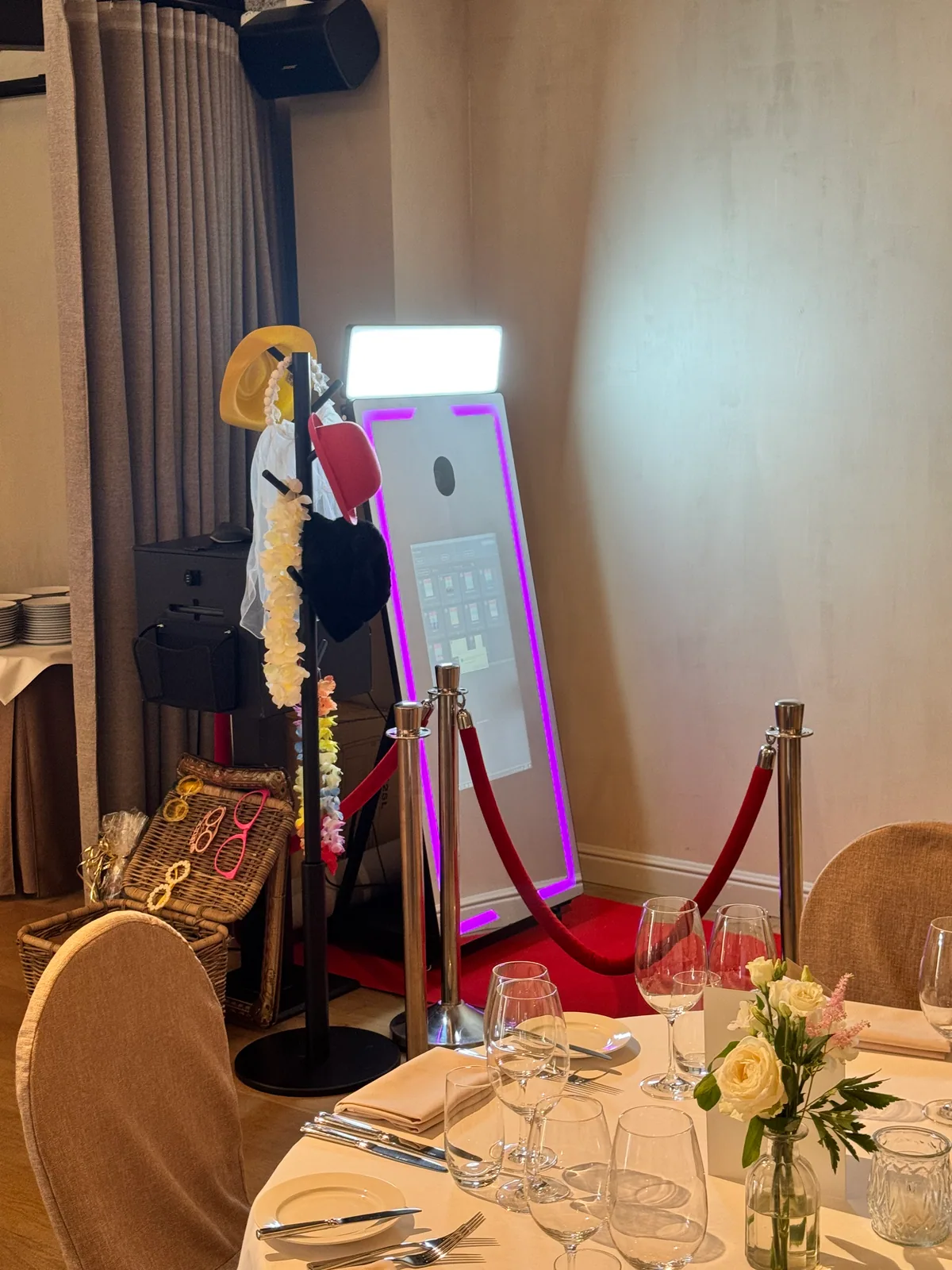 Mirror Booth met printer, props, rode loper en afzetpalen in een feestelijk ingerichte zaal.