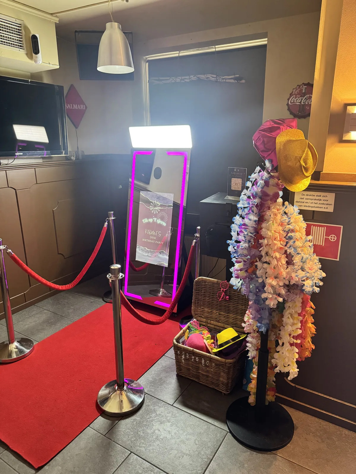 Complete Mirror Booth-opstelling met rode loper, props en paarse verlichting in een feestzaal.
